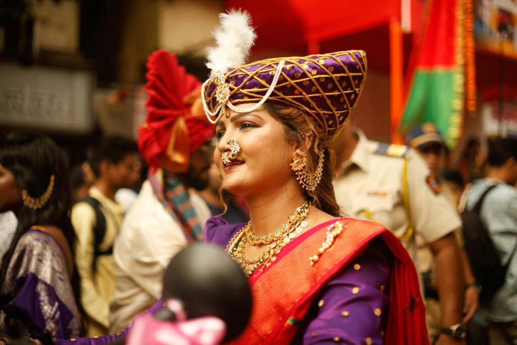 Woman in traditional attire celebrates a cultural festival in India.